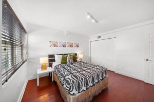 a white bedroom with a bed and a window at South Beach Family & Pet Friendly with Free Parking in Miami Beach