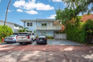 two cars parked in a parking lot in front of a house at South Beach Family & Pet Friendly with Free Parking in Miami Beach