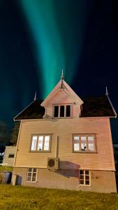 een huis met het noorderlicht in de lucht bij Villa Arctica in Tromsø