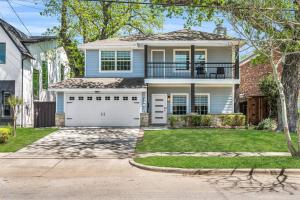 una casa azul con garaje blanco en Highland Cottage Central Huge Yard HOT TUB, en Dallas