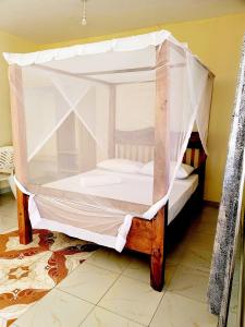 Cette chambre comprend un lit à baldaquin. dans l'établissement Casuarina Lounge, à Malindi