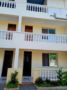 Cette maison blanche dispose d'un balcon blanc. dans l'établissement Casuarina Lounge, à Malindi