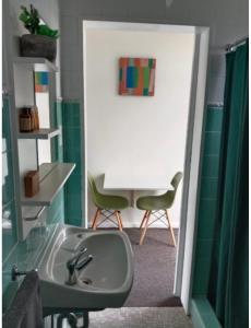 a bathroom with a sink and a chair in it at Norfolk Pines Motel in Merimbula