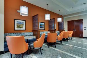 a waiting room with orange chairs and a table at Drury Inn & Suites Knoxville West in Knoxville