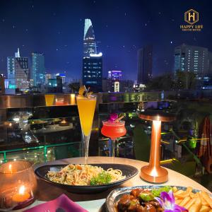 due piatti di cibo su un tavolo con vista sulla città di Happy Life Grand Hotel & Rooftop Skybar ad Ho Chi Minh