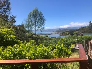 una panchina in legno con vista sul fiume. di Heron Hideaway at First Light Rangihaeata Retreat a Rangihaeata