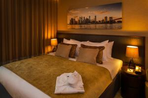 een hotelkamer met een groot bed met handdoeken erop bij Genting Hotel & Spa at Resorts World Birmingham in Bickenhill