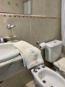 uma casa de banho com um lavatório, um WC e uma toalha em Brisas del Lago Apartamentos em Colón