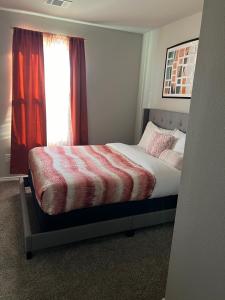 Schlafzimmer mit einem Bett und einem Fenster mit roten Vorhängen in der Unterkunft Gorgeous, Brand New 3 Bedrooms Home- Built 2024, Near SeaWorld & Lackland AFB in San Antonio