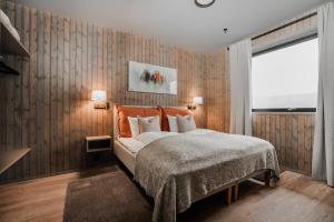 a bedroom with a bed and a wooden wall at Pellestova Hotell Hafjell in Hafjell