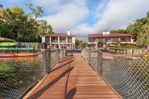 einen Holzsteg, der zu einem Resort mit einem Gebäude führt in der Unterkunft Bryan's Spanish Cove in Orlando