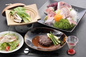 a table with three plates of food and a bowl of food at 伊豆高原 記念日を祝う宿 自然家 Haco しぜんや ハコ in Ito