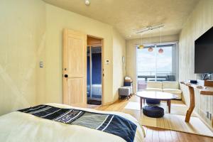 a bedroom with a bed and a table in a room at 伊豆高原 記念日を祝う宿 自然家 Haco しぜんや ハコ in Ito