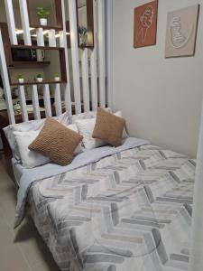 ein Bett mit zwei Kissen darauf in einem Schlafzimmer in der Unterkunft Paula' s cozy Haven in Lapu Lapu City