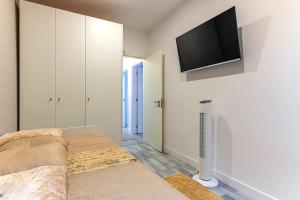 a living room with a couch and a tv on the wall at MyPlaceLisbon - Lumiar Luxury House in Lisbon