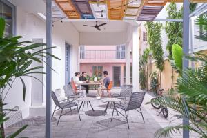 eine Gruppe von Menschen, die an einem Tisch auf einer Terrasse sitzen in der Unterkunft M Village Lý Chính Thắng in Ho-Chi-Minh-Stadt