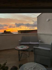 a balcony with a couch and a table and a sunset at B&B Casa CamiLory in San Lucido