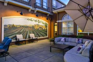 un patio con divani e sedie di fronte a un dipinto di Hilton Garden Inn Napa a Napa