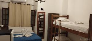 1 dormitorio con 2 literas y espejo en Hope Pousada, en Arraial do Cabo