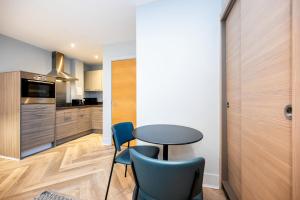 - une cuisine avec une table et des chaises dans la chambre dans l'établissement Staycity Aparthotels Edinburgh West End, à Édimbourg