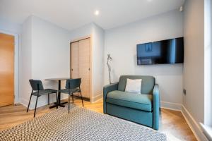 un salon avec une chaise bleue et une table dans l'établissement Staycity Aparthotels Edinburgh West End, à Édimbourg