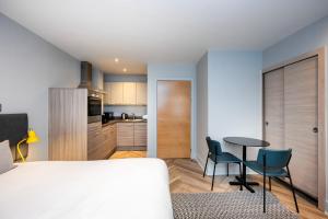 - une chambre avec un lit, une table et des chaises dans l'établissement Staycity Aparthotels Edinburgh West End, à Édimbourg