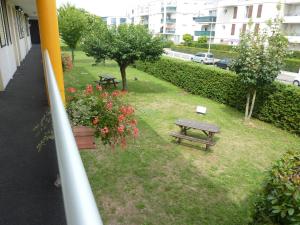 a park with a bench and a picnic table and flowers at Premiere Classe Strasbourg Ouest in Strasbourg