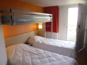 a hotel room with two beds and a window at Premiere Classe Strasbourg Ouest in Strasbourg