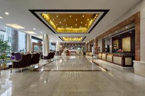 um átrio do hotel com cadeiras e um tecto grande em Shenzhen Hanyong Hotel Fuyong Branch em Shenzhen