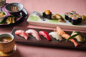 un plato de sushi y otra comida en una mesa en Shinagawa Prince Hotel, en Tokio