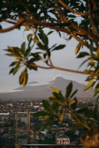 een berg in de verte met uitzicht op een stad bij PULANG ke UTTARA in Yogyakarta