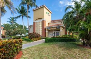 budynek z palmami przed dziedzińcem w obiekcie Extended Stay America Suites - Boca Raton - Commerce w mieście Boca Raton