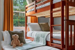 a teddy bear sitting on a couch in a room with bunk beds at Retro Revival - Mid-Century Refuge with a '70s Twist in Alachua