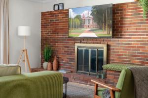 a brick fireplace with a tv on a brick wall at Retro Revival - Mid-Century Refuge with a '70s Twist in Alachua