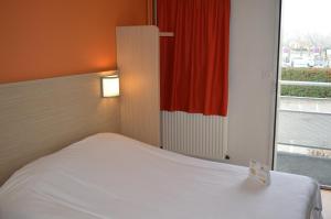 a bedroom with a white bed and a window at Premiere Classe Strasbourg Ouest in Strasbourg