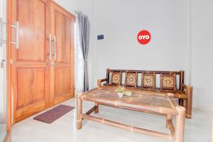 een kamer met een tafel en een houten deur bij OYO 94364 Dalinah Homestay in Yogyakarta