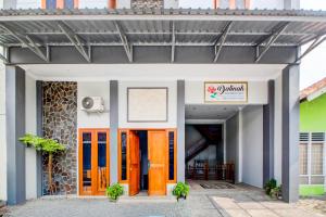 een gebouw met oranje deuren en een bord erop bij OYO 94364 Dalinah Homestay in Yogyakarta