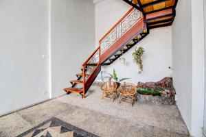 een kamer met een trap met een bank en stoelen bij OYO 94364 Dalinah Homestay in Yogyakarta