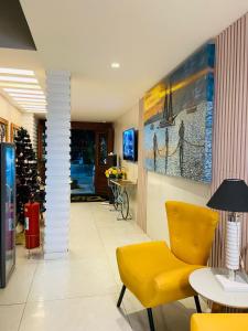 a living room with a yellow chair and a christmas tree at Pousada Capua Buzios in Búzios