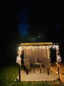 a gazebo with a table and chairs and lights at Stayatsas Tiny House Julia in de bossen op de Veluwe! in Epe