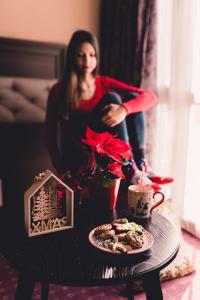 a woman sitting in a chair next to a table with a candle at Business Hotel Plovdiv in Plovdiv