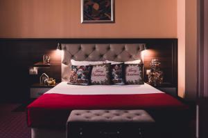 a bedroom with a large bed with a red blanket and pillows at Business Hotel Plovdiv in Plovdiv