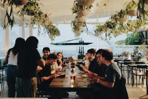 een groep mensen die rond een houten tafel zitten bij PULANG ke UTTARA in Yogyakarta