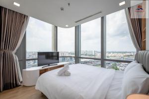 1 dormitorio con cama blanca y escritorio con ordenador en Landmark 81 Skyline Residence Suite, en Ho Chi Minh