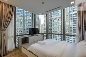 1 dormitorio con cama blanca y ventana grande en Landmark 81 Skyline Residence Suite, en Ho Chi Minh