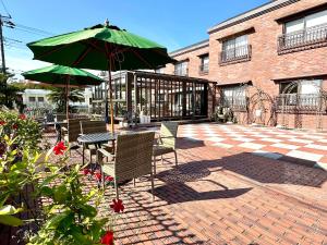 a patio with a table and a green umbrella at Izu Kogen Ocean Resort, Ito Villa-TOKI- in Ito