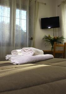 a pile of towels sitting on top of a bed at Hotel Al Verde in Mandello del Lario