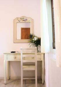 a white desk with a mirror and a vase of flowers at Hotel Al Verde in Mandello del Lario