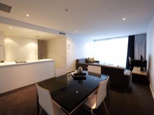 a living room with a dining table and a couch at Quest Parnell Serviced Apartments in Auckland