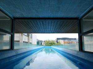 an empty swimming pool in a building with windows at Quest Parnell Serviced Apartments in Auckland